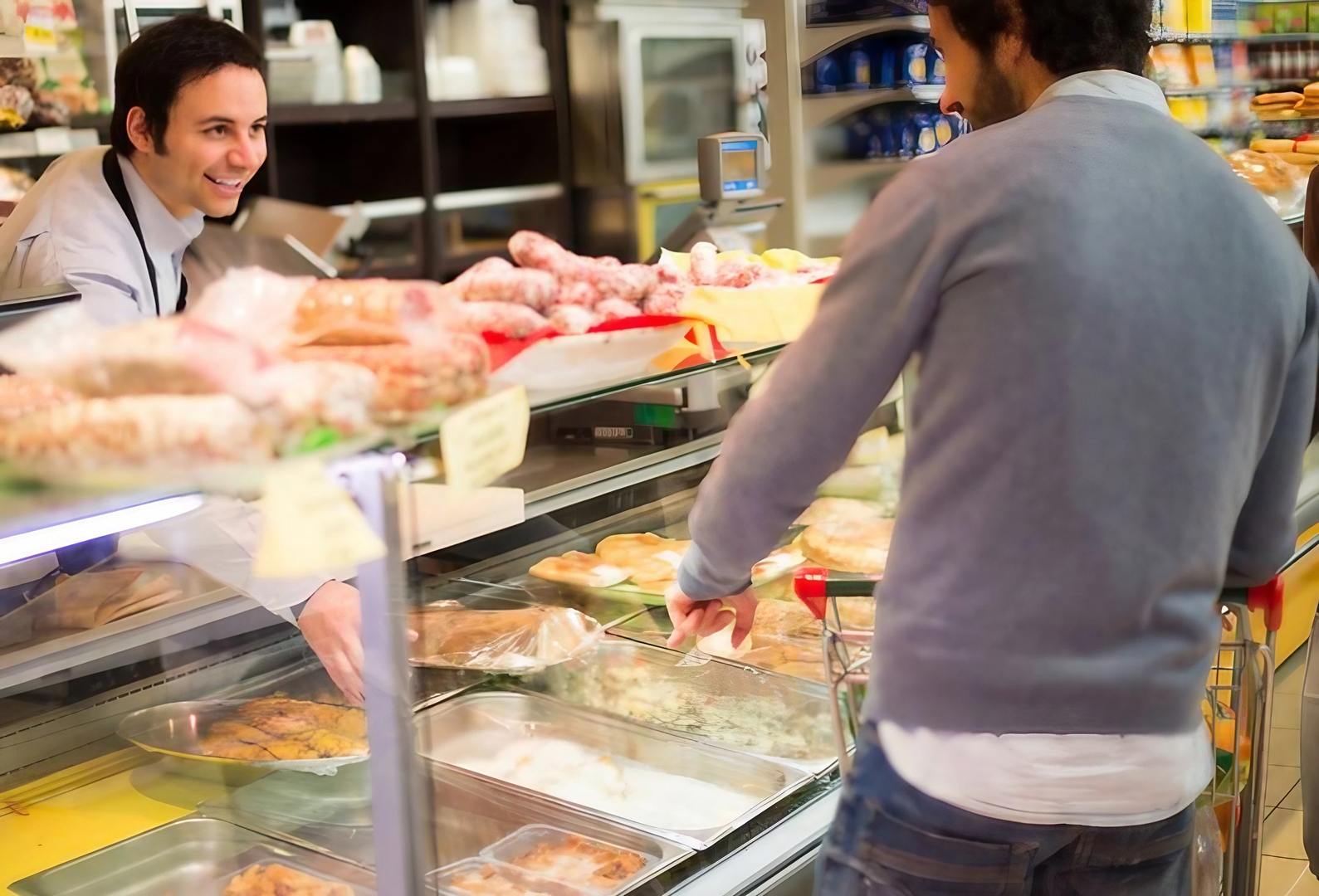 Mann an einer Metzgereitheke